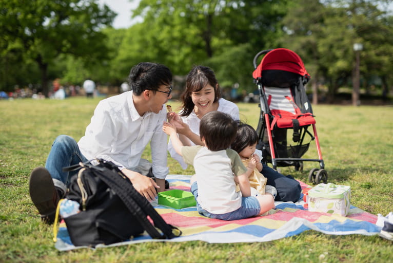 自宅周辺の公園でピクニックを楽しむ家族