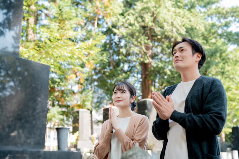 2026年のお盆にお墓参りをする夫婦